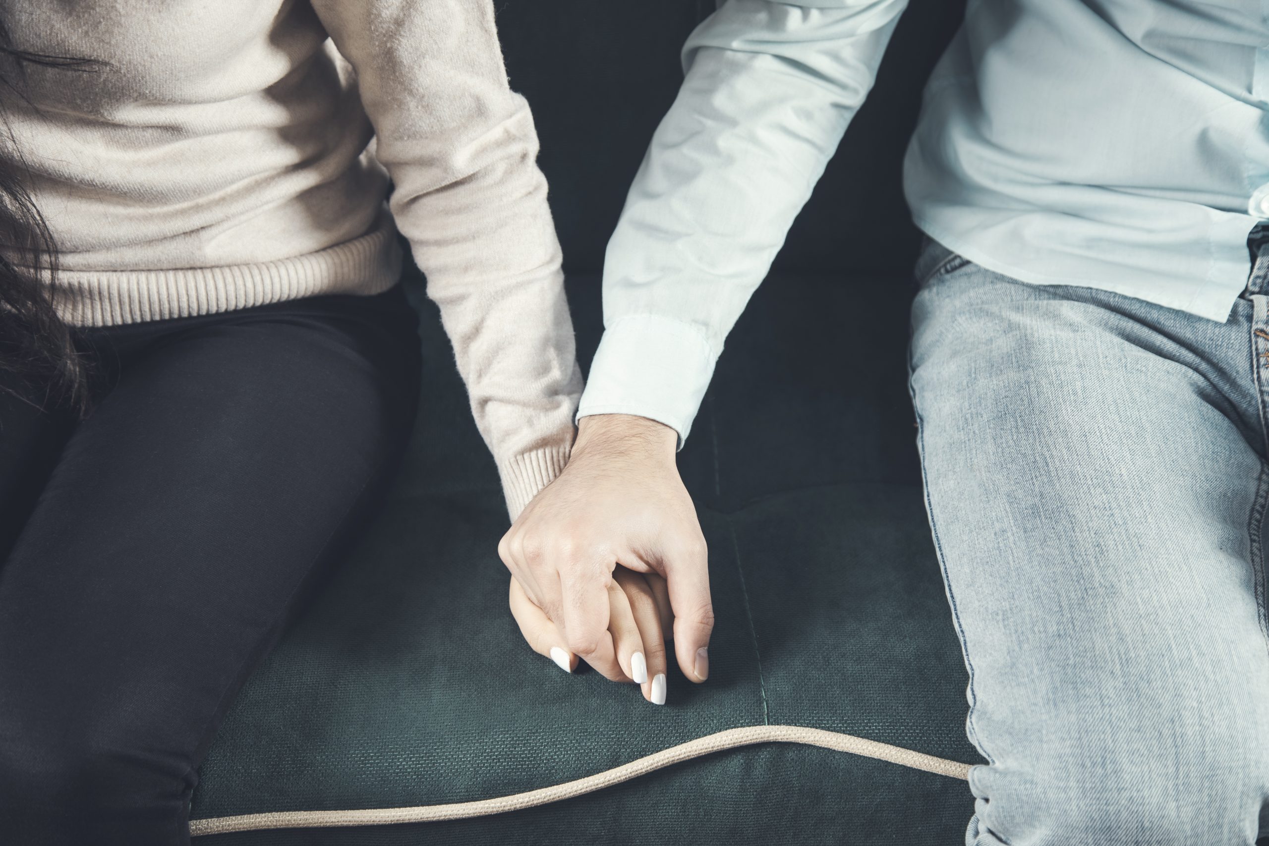 man and woman hold hands on sofa vecteezy_family-couple-ignoring-each-other-after-a-quarrel-two_46672670.jpg