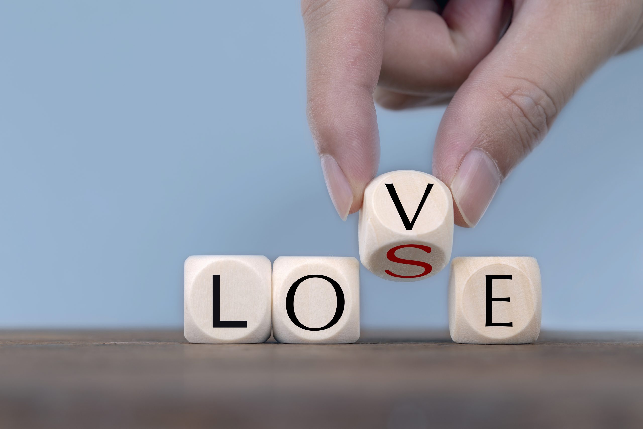 Hand Changing word from love to lose On Wooden Cube Hand flipping “LOSE” to “LOVE” with wooden blocks, symbolising couples therapy and relationship healing in West Sussex.