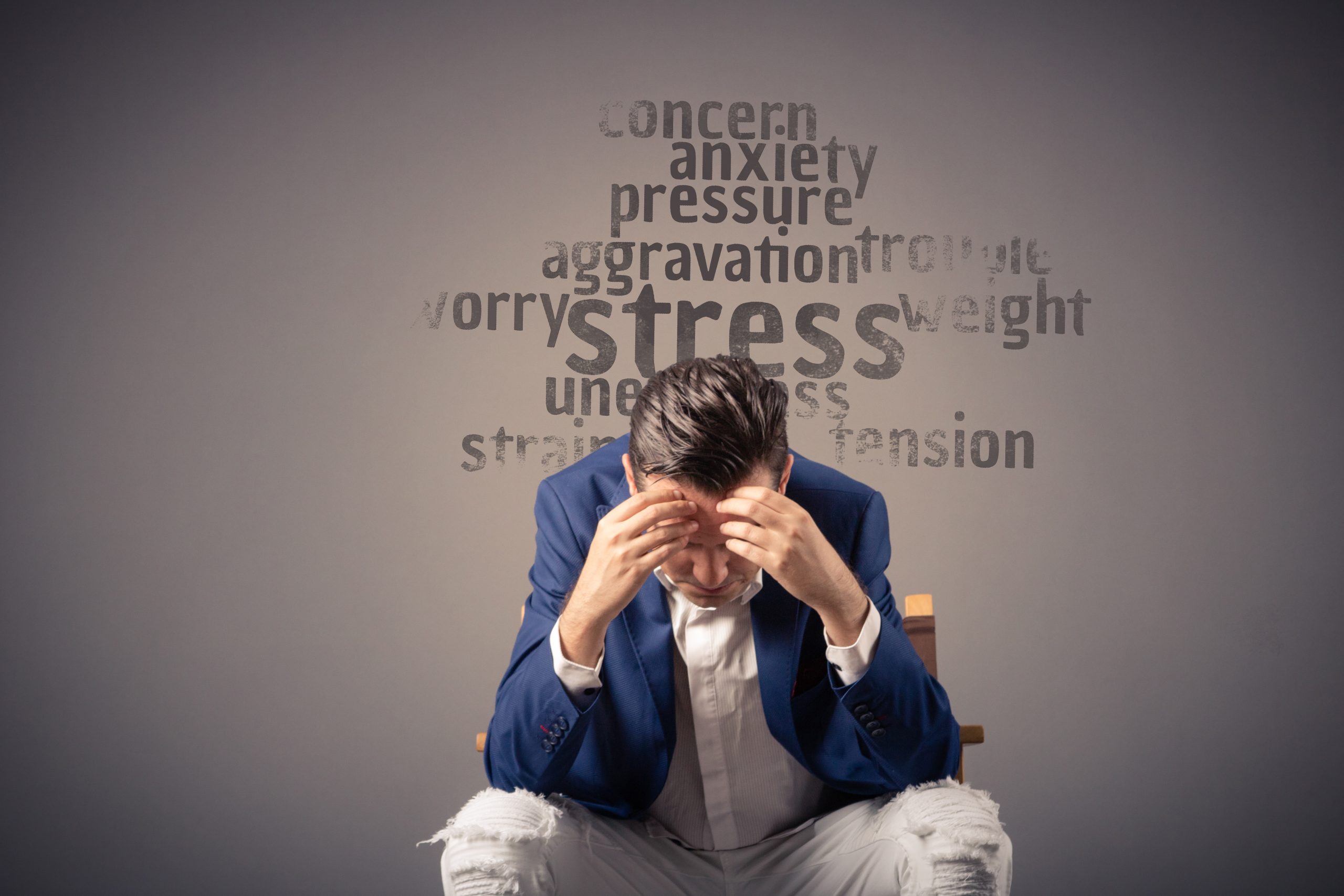 Overworked businessman having headache due to stress at work. Eleos Counselling West Sussex, Counselling for workplace stress