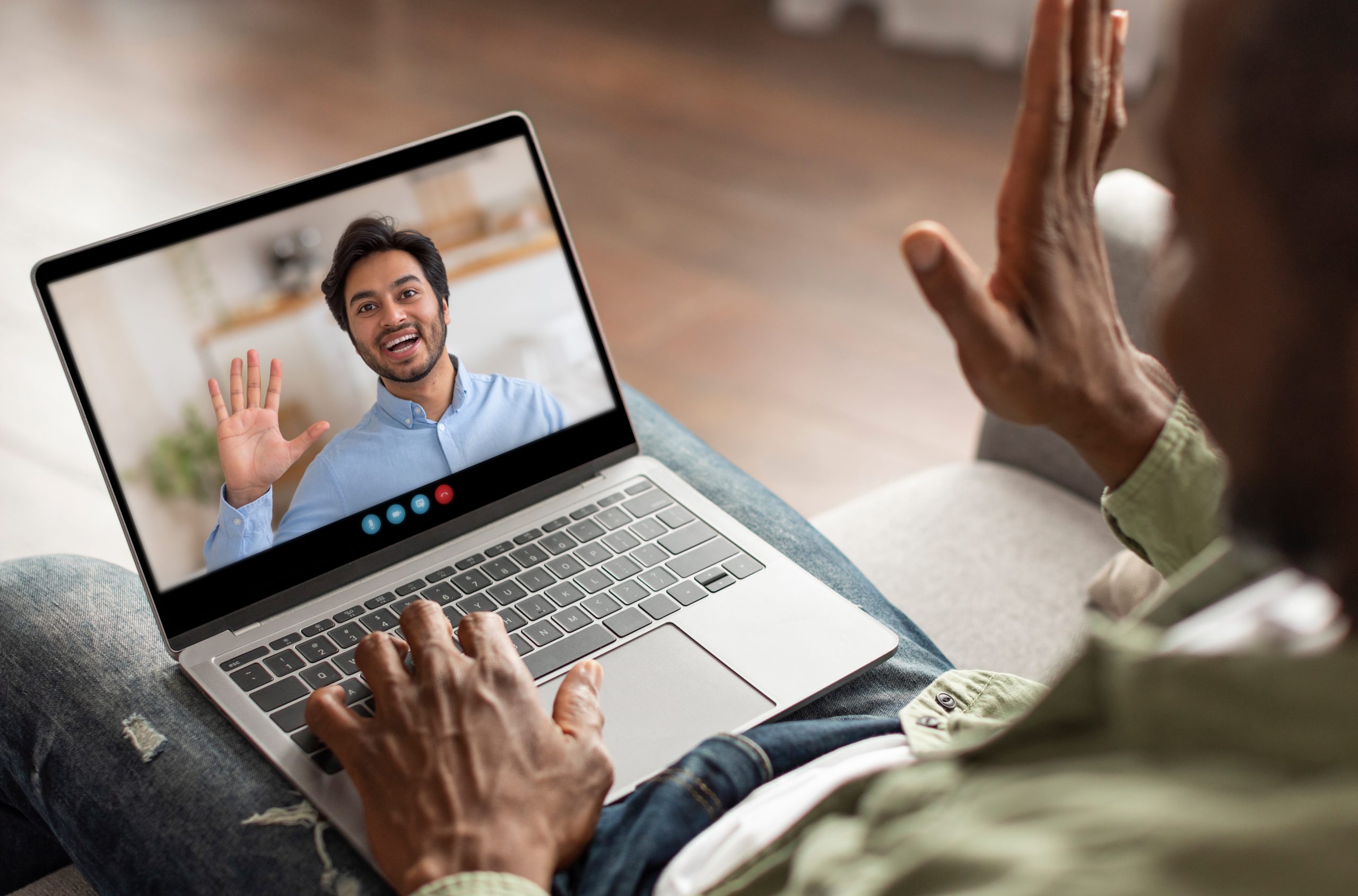 Man waving during a video call from his home office in the afternoon Online Counselling and Psychotherapy with Eleos Counselling<br />
Your Journey Towards Healing Starts Here