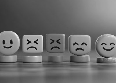 Row of simple facial expression tokens showing different emotions, representing emotional awareness and regulation in therapy for pornography and sex addiction in West Sussex
